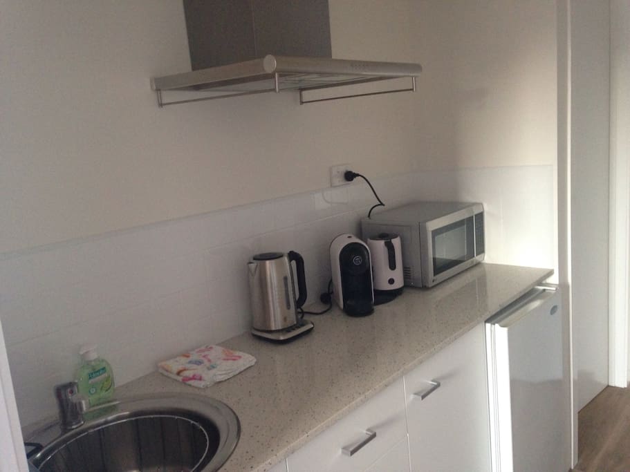 The kitchen, including kettle, toaster, coffee machine, microwave, fridge, and hot plate, as well as general crockery and glasses.