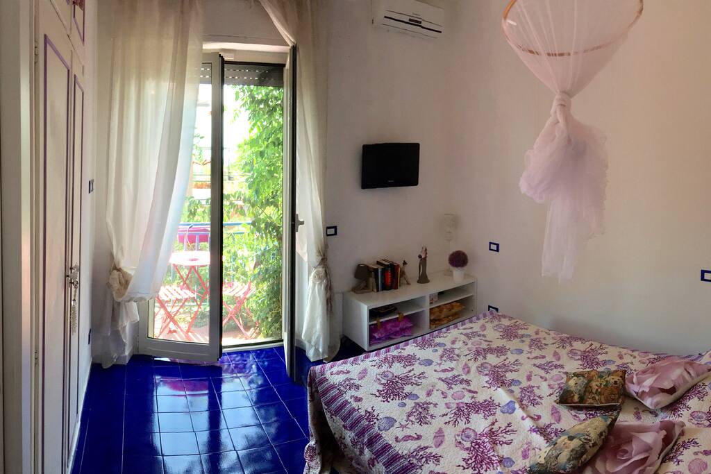 Camera da letto matrimoniale con balconcino e vista mare.