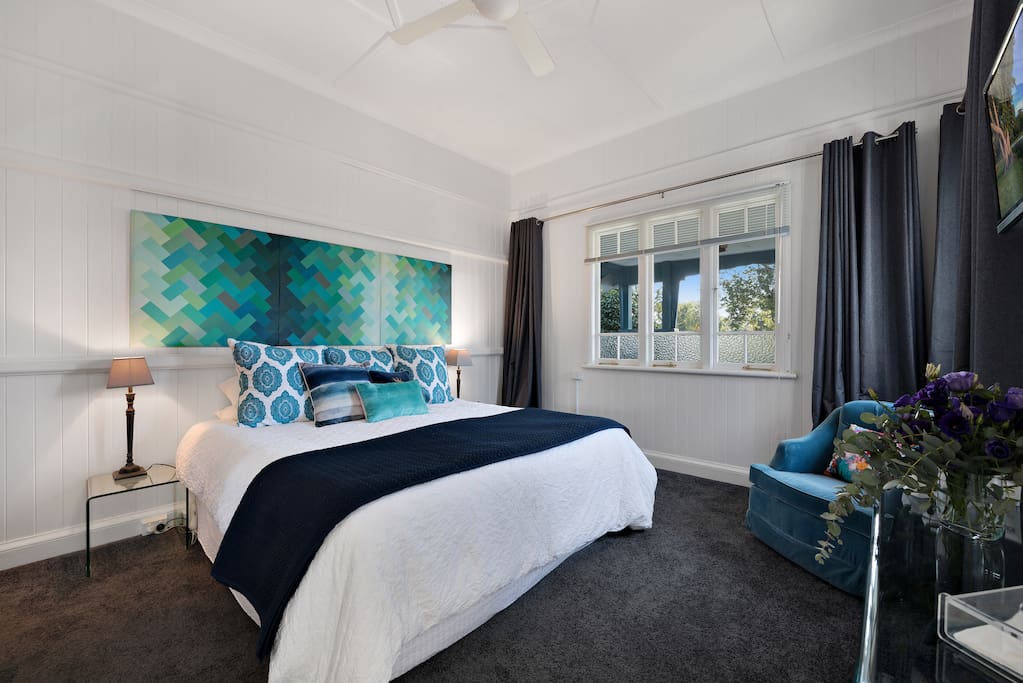 Stylish master bedroom with king sized bed and personal TV