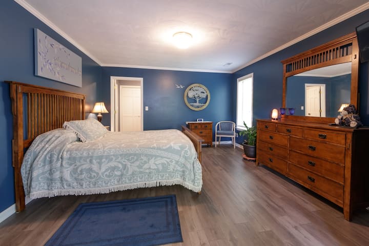 Primary Bedroom is located on the second floor, with a queen  bed, Dressing Room, en-suite bathroom, and Sunroom with fireplace.