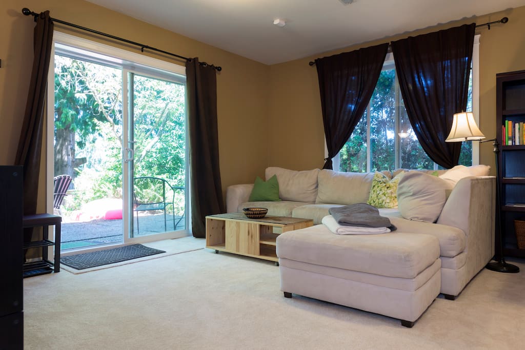 This spacious haven, all areas, are yours and only yours. Clean, quiet, secluded. Please scroll through photos for more details. Large Living Room with comfortable sectional sofa and ground level windows with trees outside.
Sofa is wonderful for watching tv, lounging / napping.