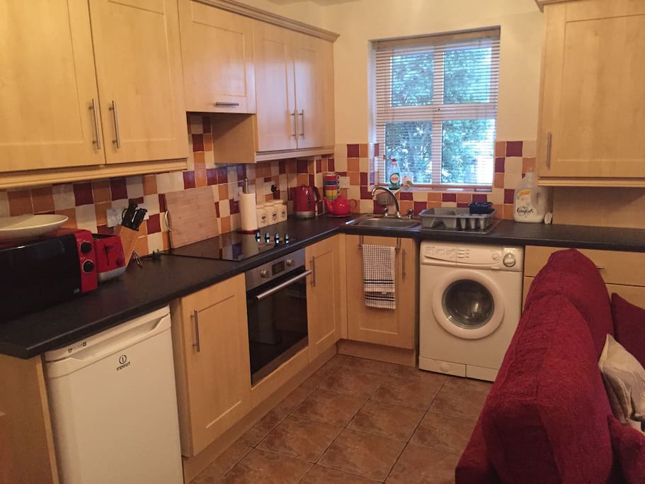 Kitchen area. Fridge, washing machine, microwave, toaster and kettle pictured.