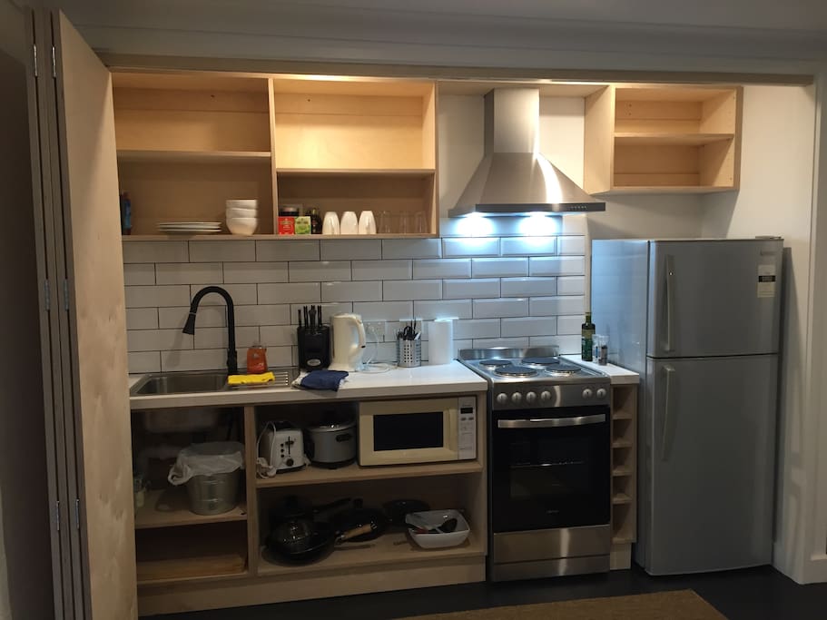 Full kitchenette with cooking utensils, cutlery and chinaware