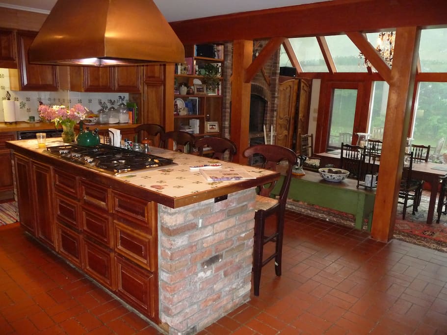 Fully equipped country eat in kitchen with fireplace by the dining area