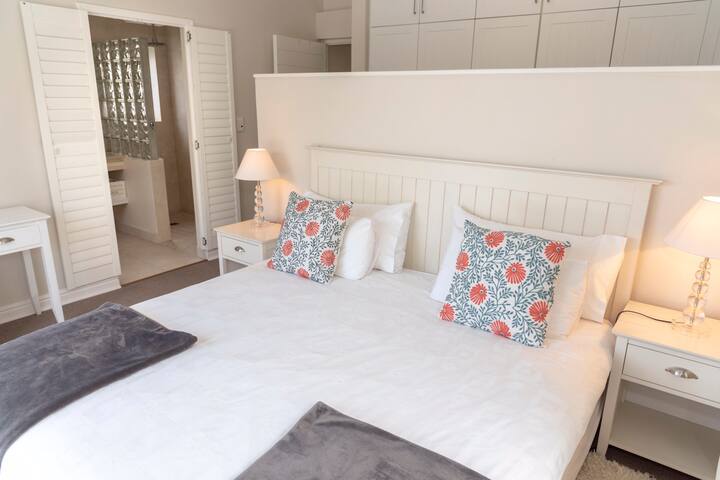 غرفة نوم رئيسية بسرير بمقاس كبير وحمام داخلي.