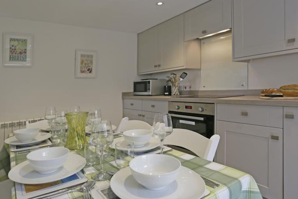 Open Plan Room with Kitchen/Dining Area: Electric oven and ceramic hob, fridge, slimline dishwasher, dining table and chairs. Tea and Coffee starter pack supplied. Utility Room Seperate