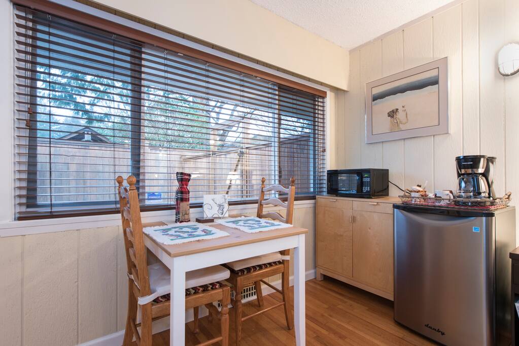 Kitchenette with fridge, microwave, kettle, toaster, dishes and cutlery.