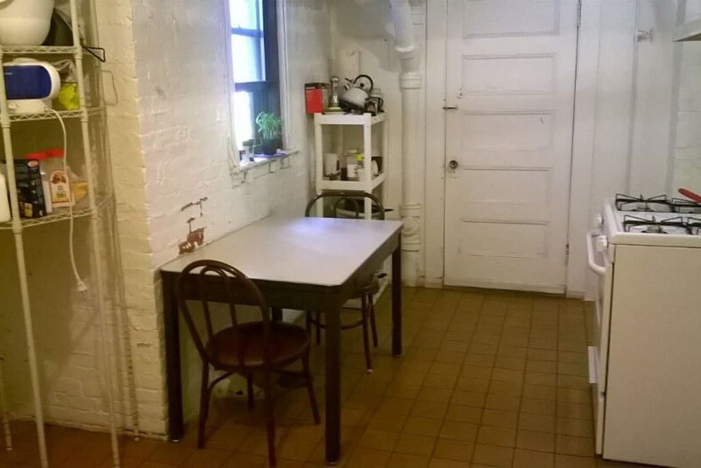 The public kitchen with a table (available for 6 people) a stove & oven, and a fridge.