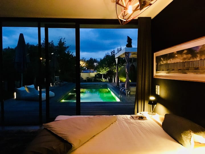 Aftenstemning i bådehuset med udsigt over poolen og brændeovnen