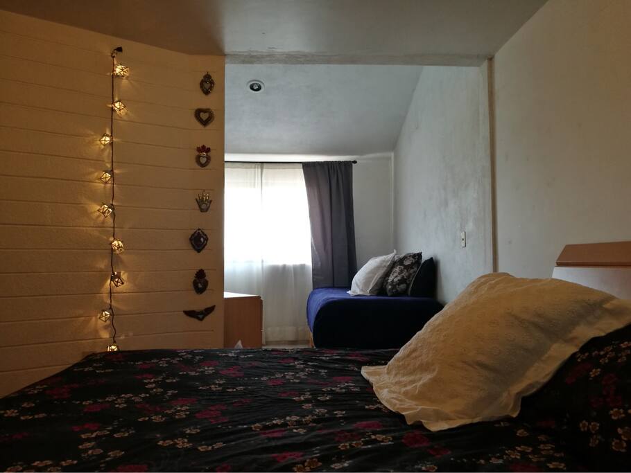 Recámara con cama tamaño queen y sofá cama, tocador y closet disponibles y ventana con vista al parque frente a la casa. / Queen size bed, sofa, window and view to park.