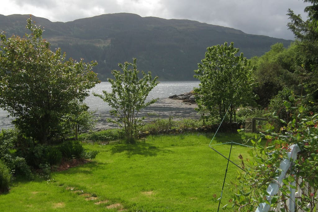 A view from the bedroom window. The steps into the garden and the gate leading to the shore can be seen to the right