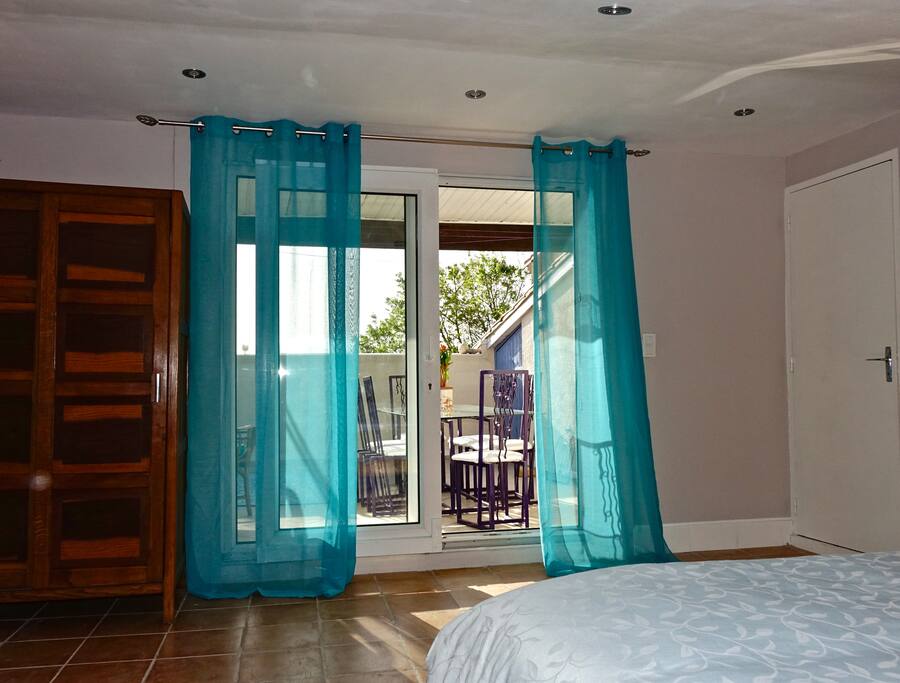 Top floor bedroom with a kingsize bed with a view to the terrace and the door to the bathroom