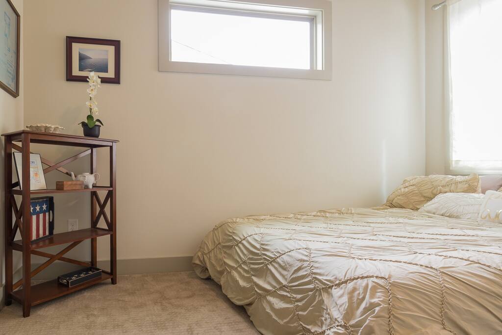 Queen bed in a private room with a closet.