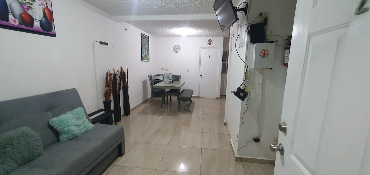 غرفة معيشة وطعام، مع تلفزيون ومناخ ومجموعة إسعافات أولية وطفاية حريق.