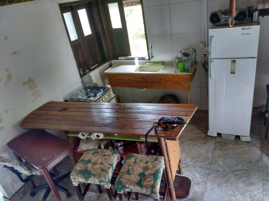 cozinha com geladeira, fogão e mesa de trabalho
