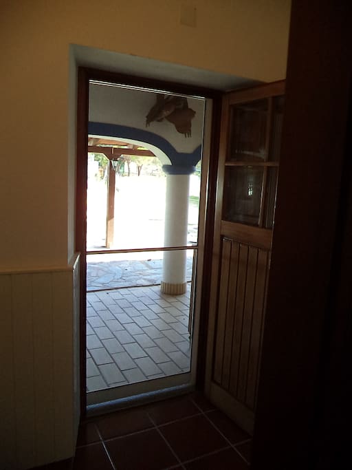 Entrada com porta dupla em madeira e porta rede de mosquiteira.