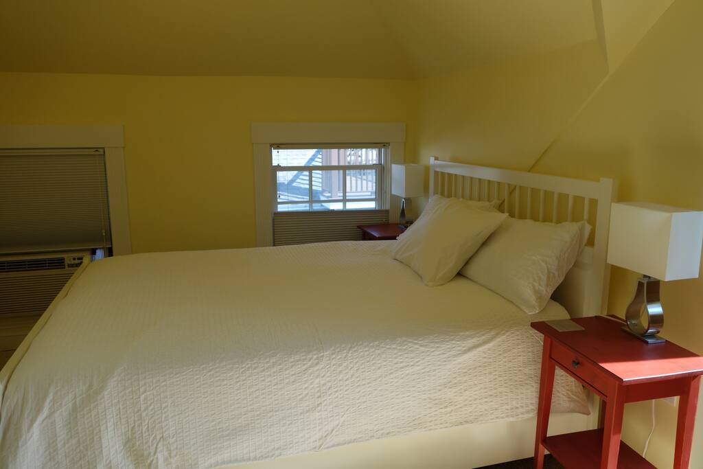 The Queen bed as the afternoon sun streams into the room.
