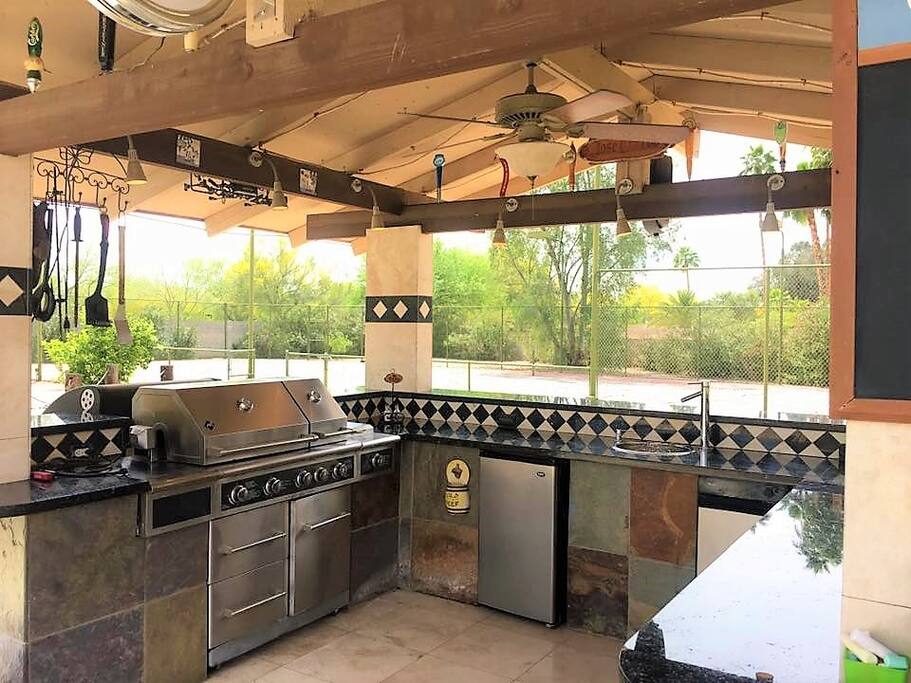 Outdoor kitchen with built in propane grill, sink, fridge, and beautiful night lighting. Unattached charcoal grill provided to accommodate your preference as well.