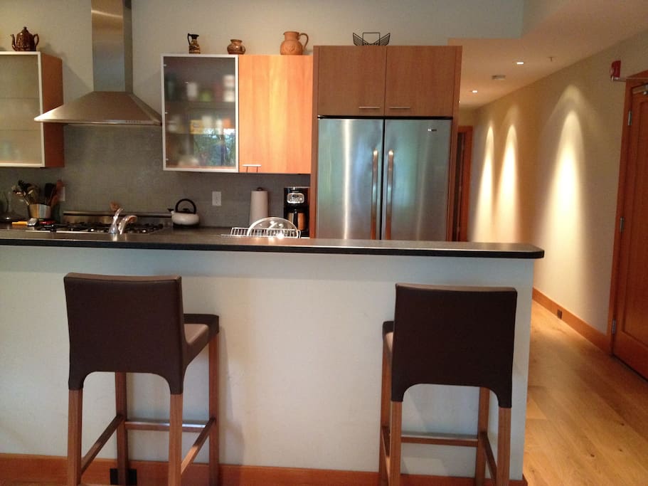 The fully-equipped gourmet kitchen has a 5-burner gas Bertazonni stove, stainless steel appliances, custom granite counters, hand crafted tiles, and seats three at the bar. An elegant dining-room table seats the whole family.