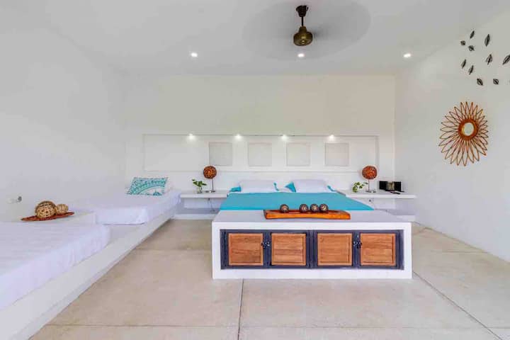 ห้องนี้มีเตียงขนาดคิงไซส์และเตียงคู่ขนาดเล็ก 2 เตียง อยู่ชั้นล่างของบ้าน มีห้องน้ำในสวน