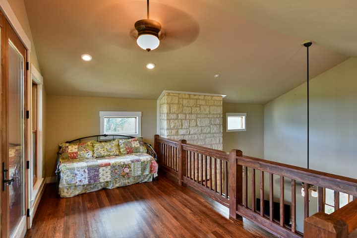 Choďte po schodoch do podkrovia s dennou posteľou, ktorá má postieľku, ktorá sa zmení na manželskú posteľ, ktorá umožňuje členom vašej skupiny spať v pohodlí.