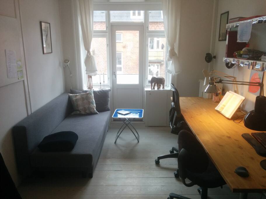 Office with small balcony and foldout sleeping couch