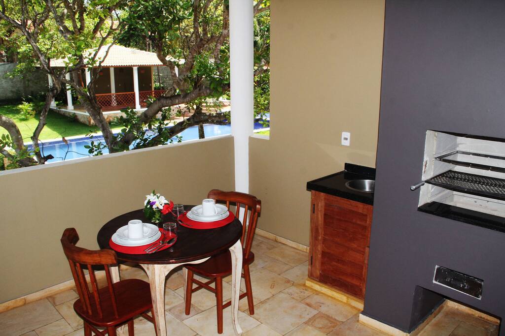 Varanda com churrasqueira e vista para a piscina