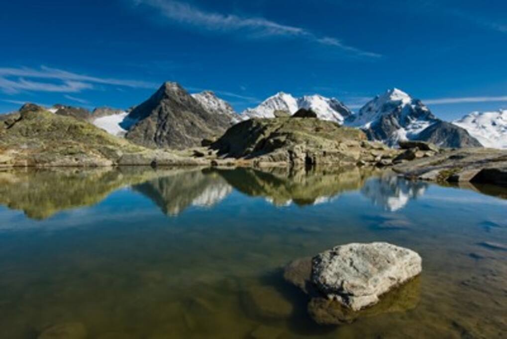 Il cielo azzurro sovrasta le catene montuose, creando un'atmosfera piacevole e rilassante.