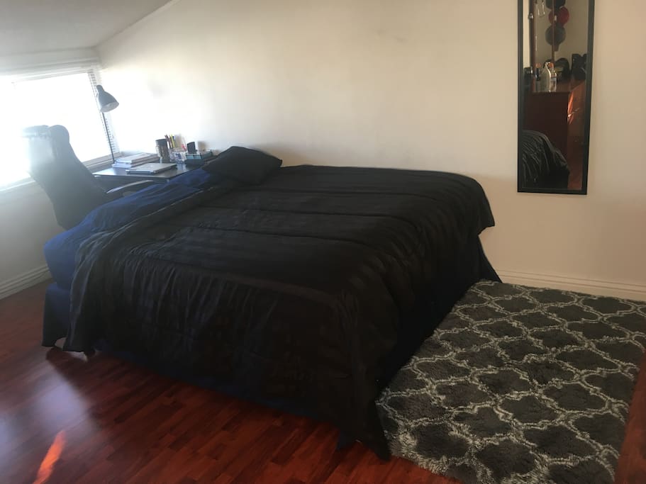 This is the bedroom, queen mattress with work desk behind it.