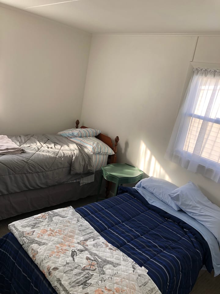 غرفة نوم بسريرين فرديين وخزانة ملابس.