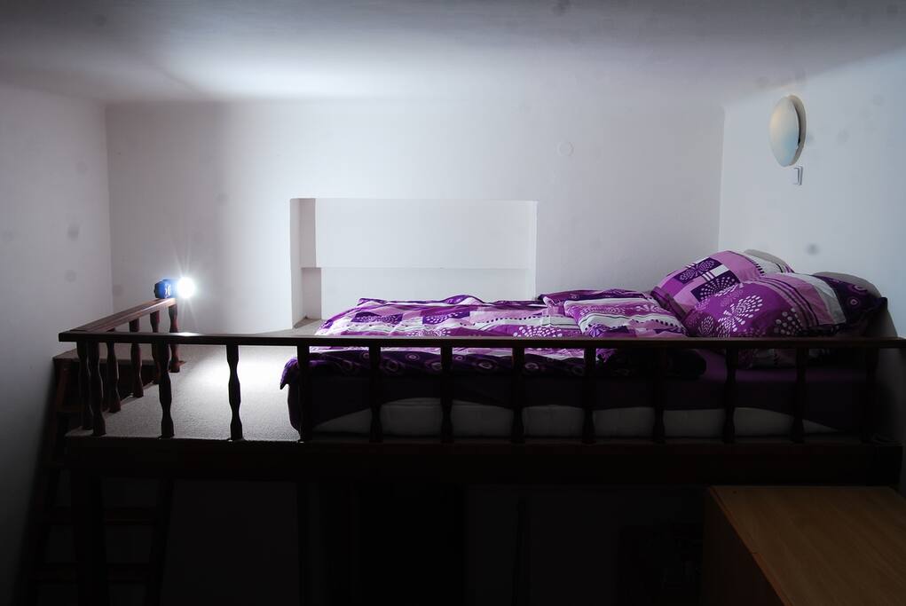 One bed is located in the upper part of the living room.