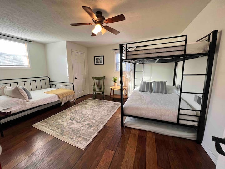 Habitación litera con literas completas sobre literas completas, un colchón completo debajo de las literas, una cama de día de tamaño completo y una cama nido doble debajo de eso.  