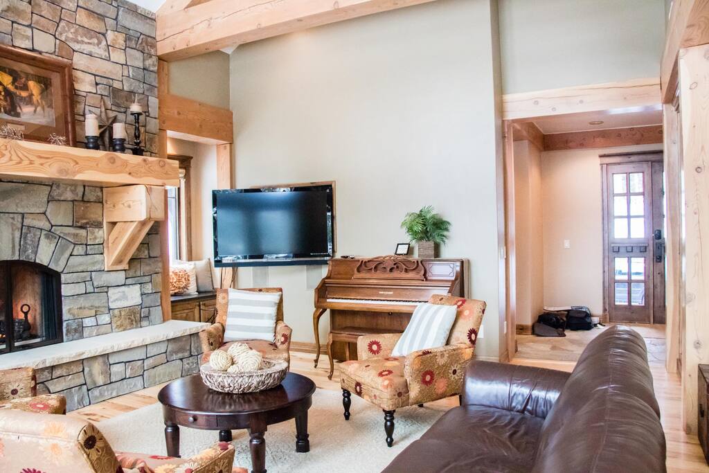 Main-level living room with cozy fireplace and piano