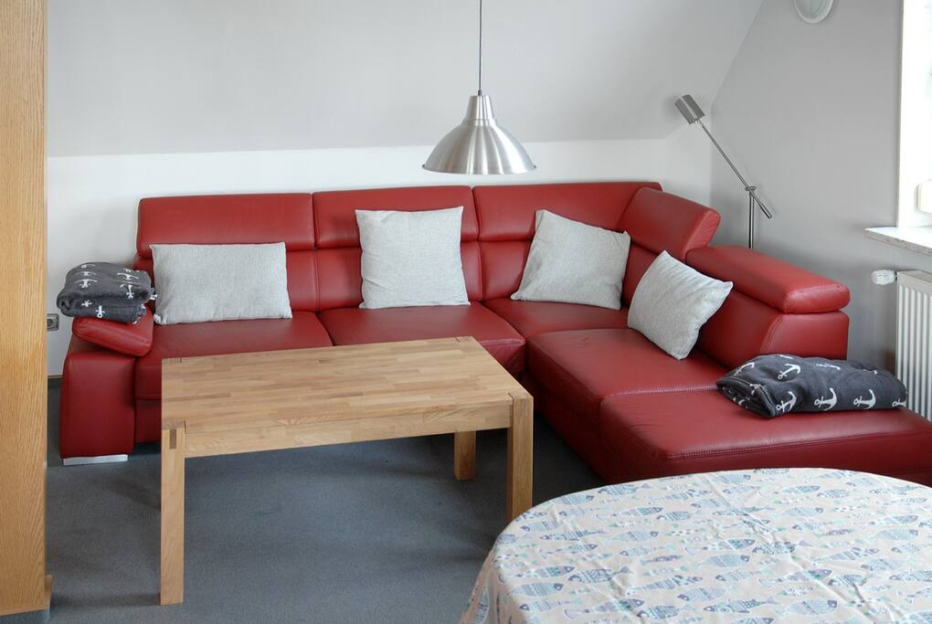 Im großzügigen Wohnraum lädt ein Lederecksofa zum Entspannen ein.