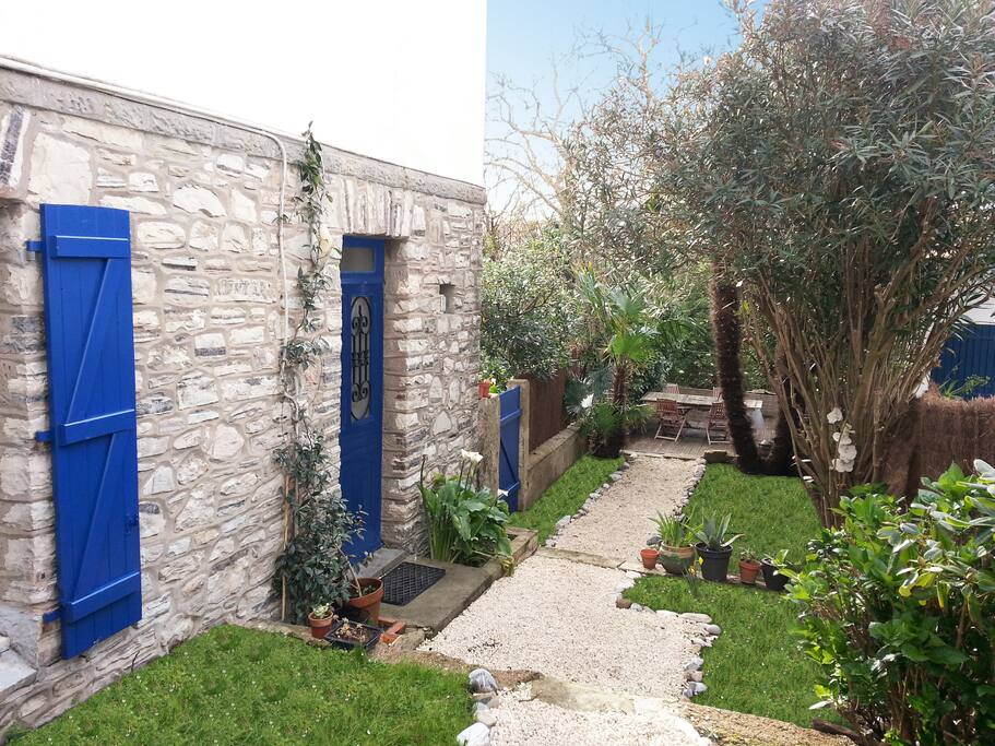 Accès à l'appartement par un jardin de 40m² donnant sur la terrasse. Le petit déjeuner à l'ombre des lauriers et des palmiers est un délice...