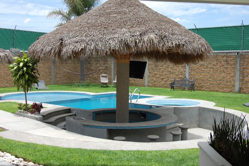 Vista de palapa de la alberca, tiene bar dentro y fuera de la alberca, con rampa