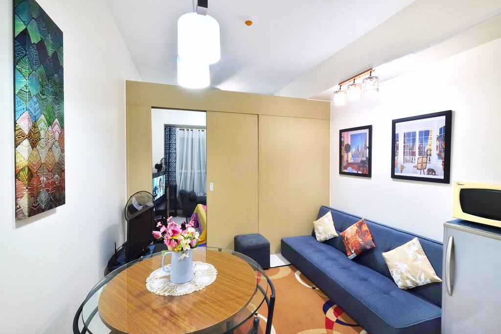 Actual living/dining room with sofa bed. Recline the back cushion and it becomes a single-size bed. Magic.
