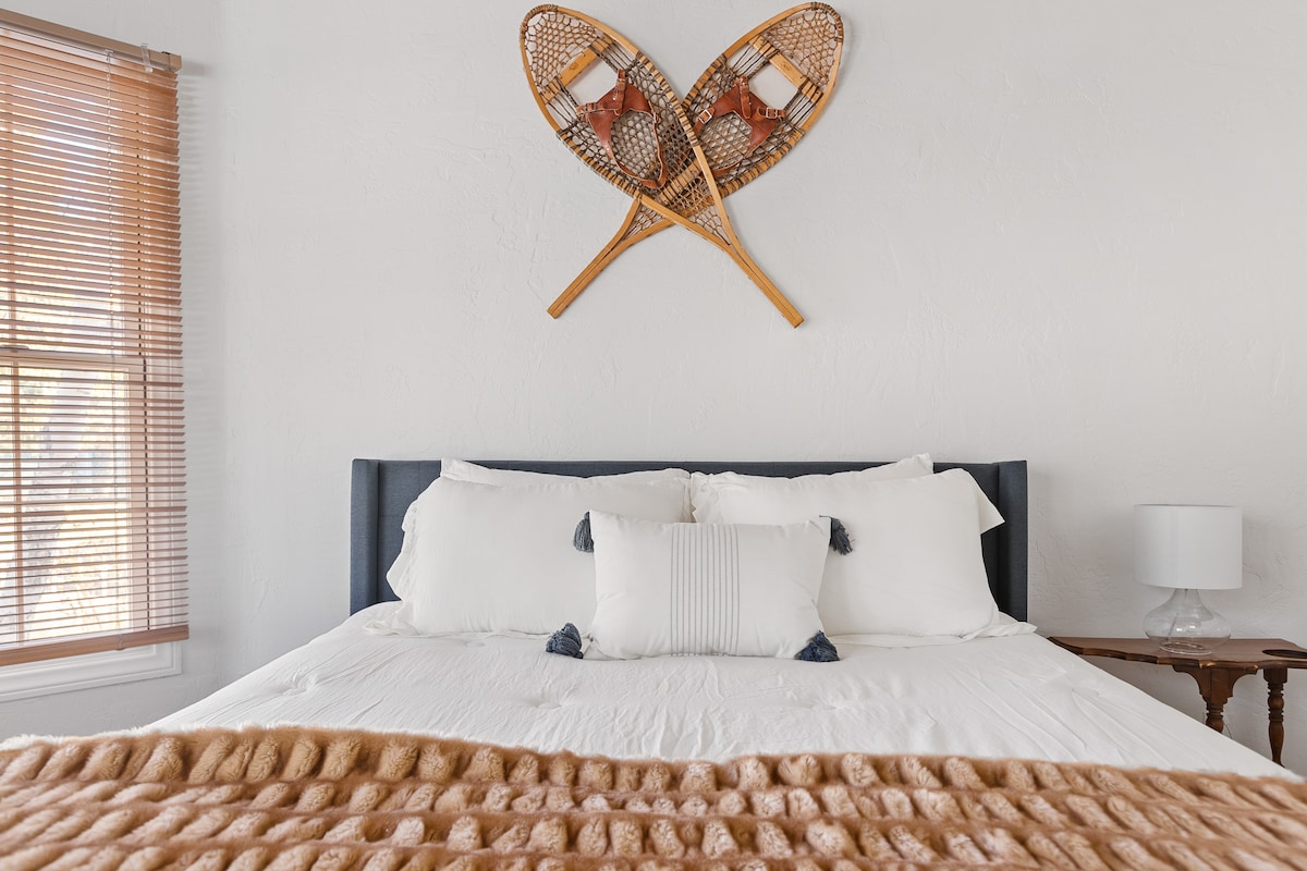 Chumba cha kulala cha Master kilicho na matandiko ya kifahari na chumba cha kulala kilicho na kitanda cha Malkia na Televisheni ya kisasa.
