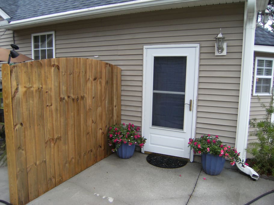 An inviting private entrance with private patio behind fence.
