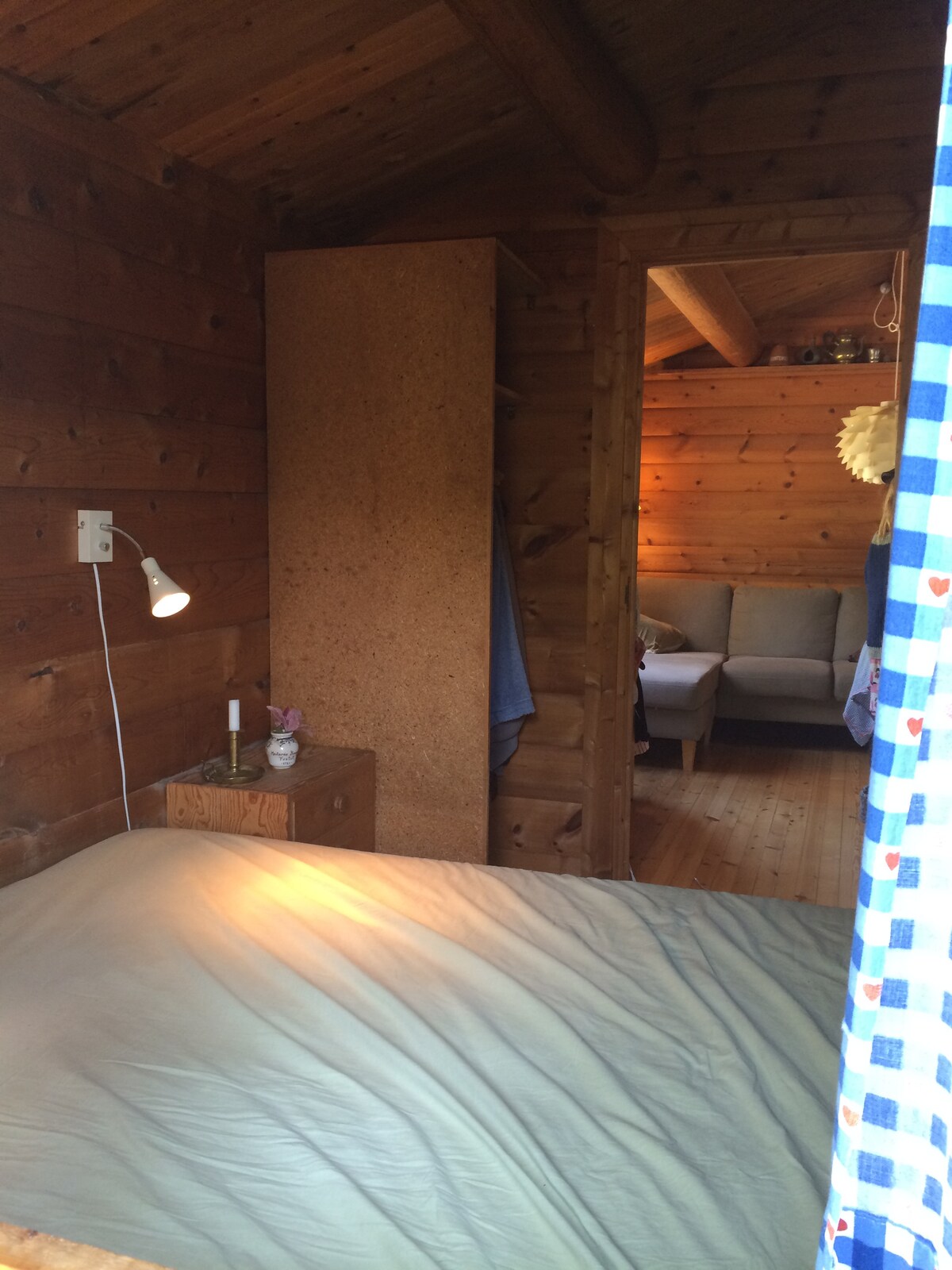 ห้องนอนพร้อมเตียงคู่มองเห็นได้จากหน้าต่างไปยังห้องนั่งเล่น