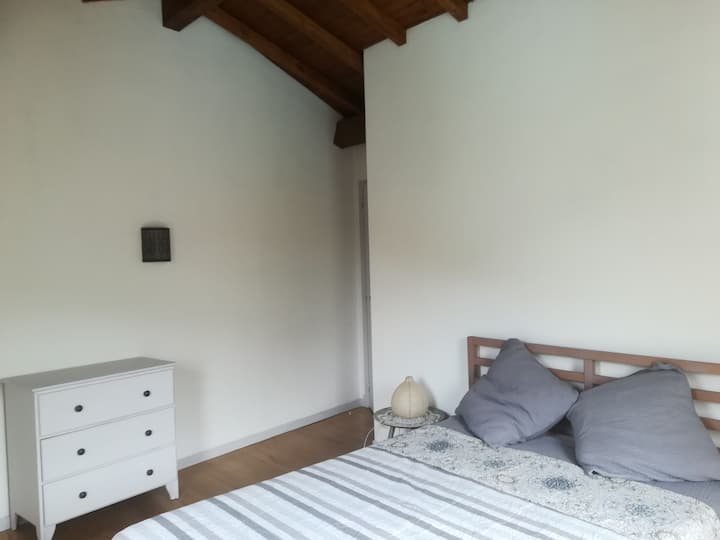 Habitación de cama doble y cuna de madera con barrotes.