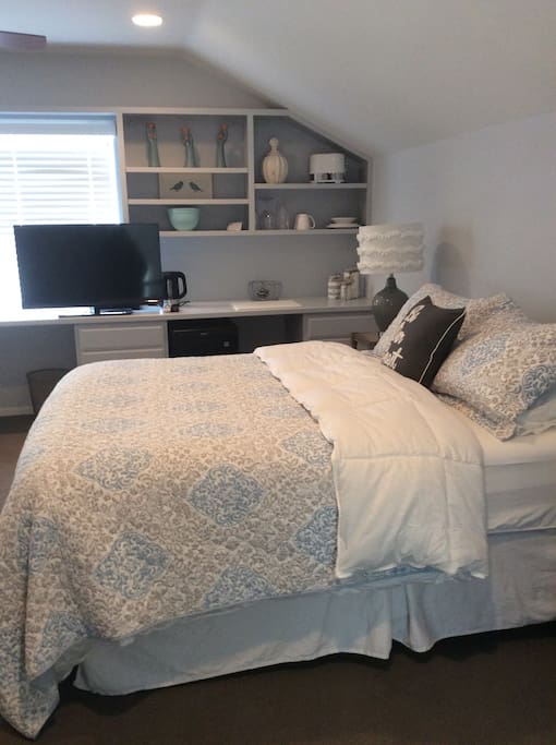 Plush queen bed, TV, desk and kitchenette area
