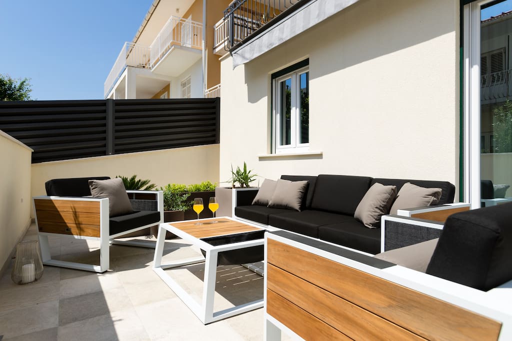 Private 46 m² terrace in front of the apartment with 2 sunbeds, three-seater, 2 armchairs and a table