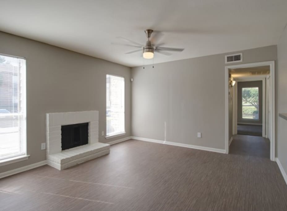 simple living room with fireplace and ceiling fan
