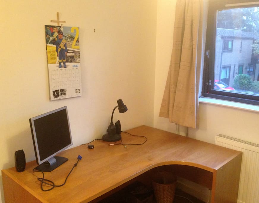 Office-size desk with extra monitor, sound and reading lamp. Bright window.