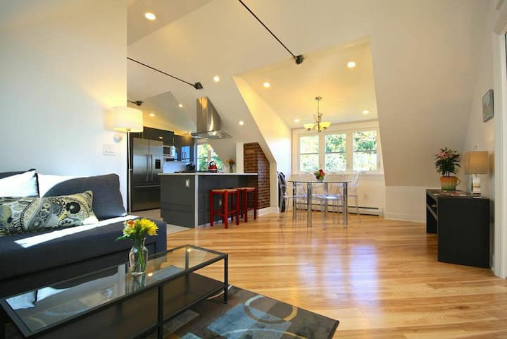 A modern and bright sitting space with high ceilings and windows in a Maine VRBO