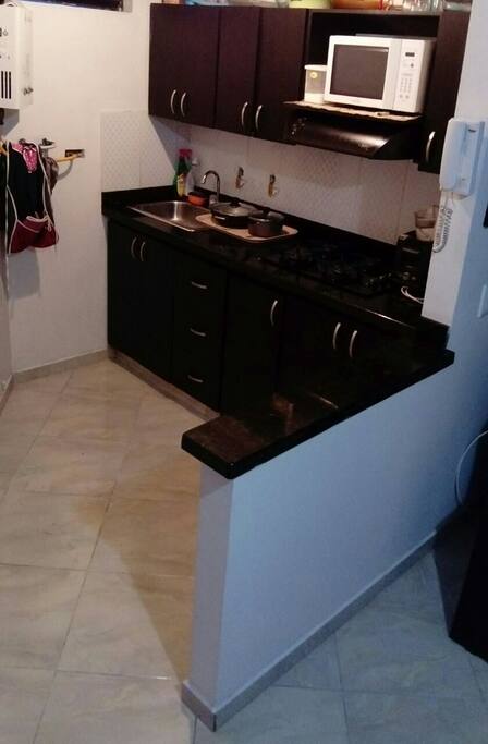 Su cocina con como espacio para sus alimentos con una buenos implementó que pueden usar