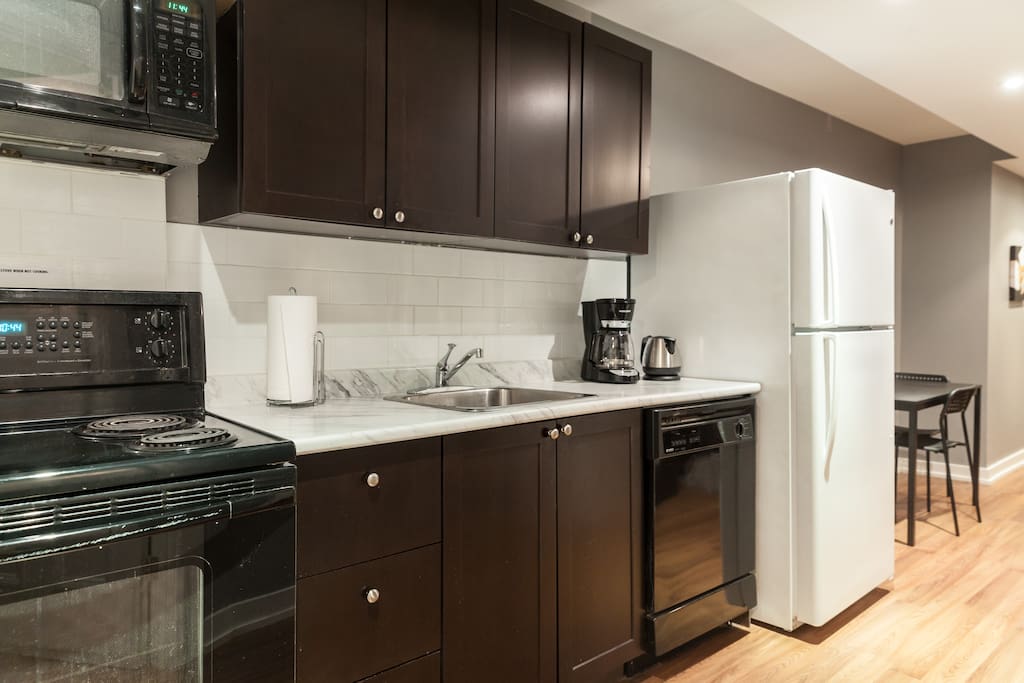 Kitchen includes dishwasher, microwave, coffee maker, kettle, & toaster.