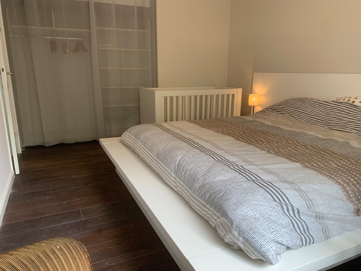 חדר שינה גדול בקומת הקרקע עם מיטה זוגית וארונות בגדים גדולים.