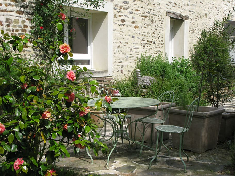 Avec ses transats, la terrasse côté jardin est verdoyante et ensoleillée.